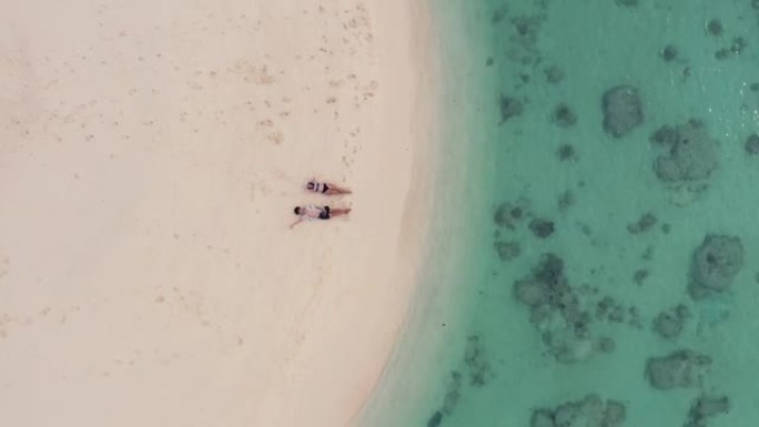 缩小躺在海滩上的夫妇