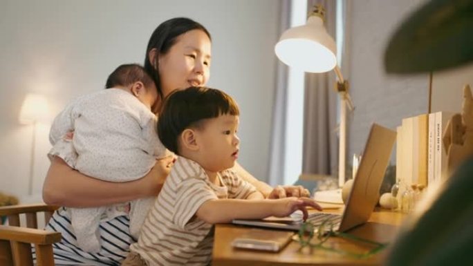 工作的女人照顾她的儿子，在家工作。