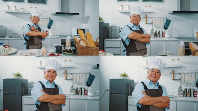 快乐厨师站在厨房里双臂交叉的肖像。
