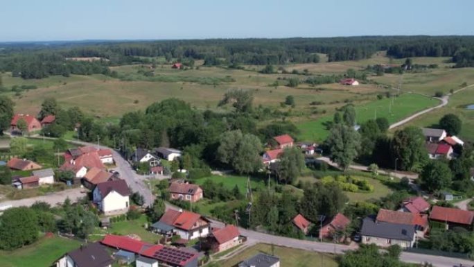鸟瞰乡村乡村景观。郊区有住宅建筑波兰。农场变成波兰的绿地。鸟瞰农舍，丘陵田地树木森林农业场。
