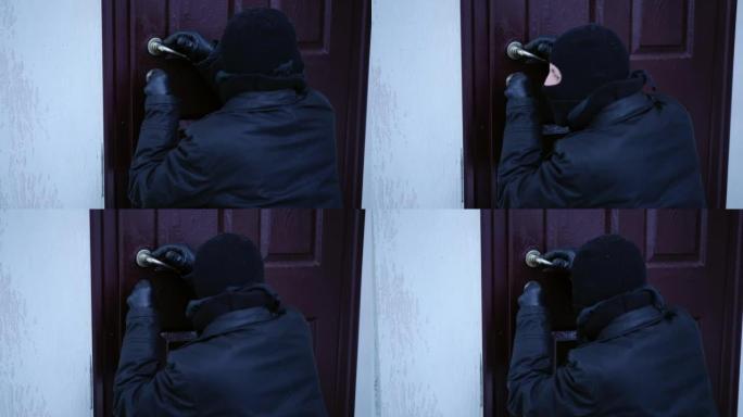 后视图小偷撬开锁环顾四周，在户外逃跑。高加索蒙面男子闯入犯罪现场的房子。违法概念。