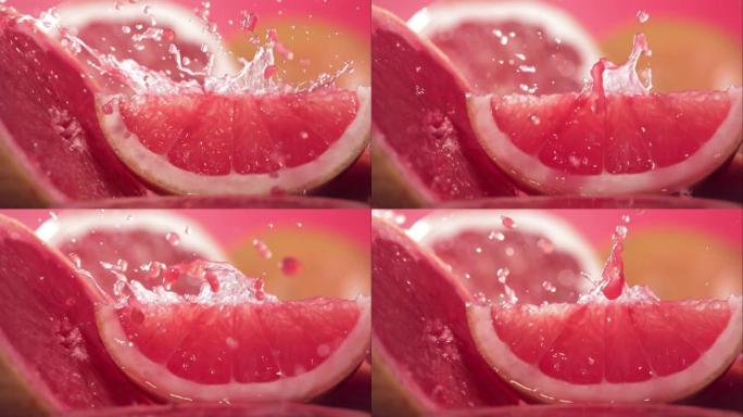 通过葡萄柚切片飞溅的葡萄柚汁的慢动作镜头