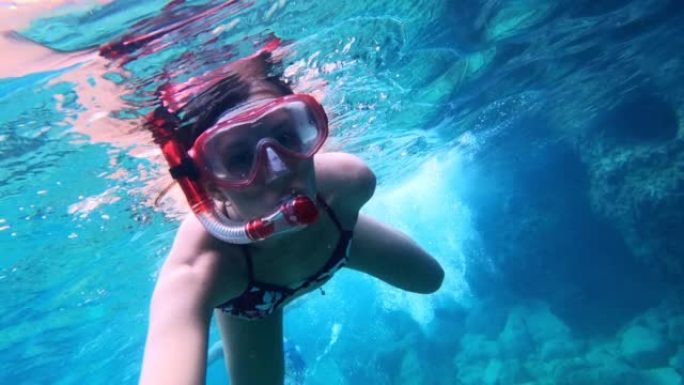 女人在海里浮潜。向可穿戴相机游泳