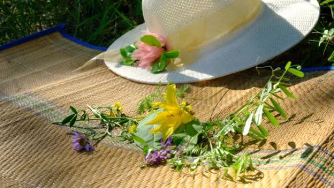 夏天的场景，草帽，竹席上的草地花，地毯。在阴凉处放松，享受大自然