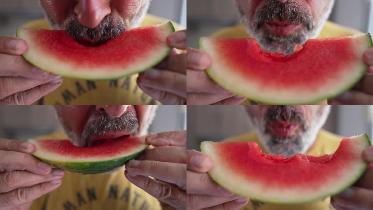 特写红西瓜片，面目全非的大胡子男人在慢动作中吃美味多汁的浆果。白人男子在夏天在室内享受甜食的味道。