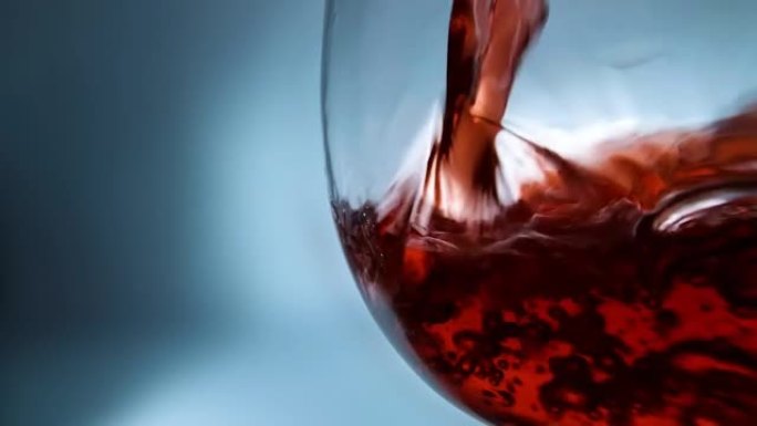 红酒倒入玻璃杯中。玻璃杯与倒红酒特写。4k微距慢动作视频。在高速电影摄像机上拍摄。