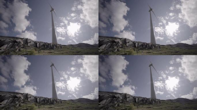 大型风车在多云的天空上的细节拍摄，山脉后面
