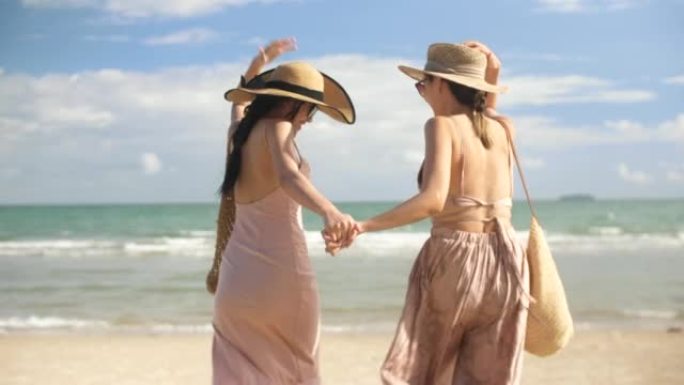 两个女人在假期享受快乐地在海滩上跑步