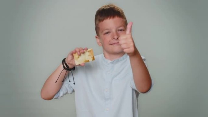蹒跚学步的男孩展示塑料信用卡广告转账无现金网上购物