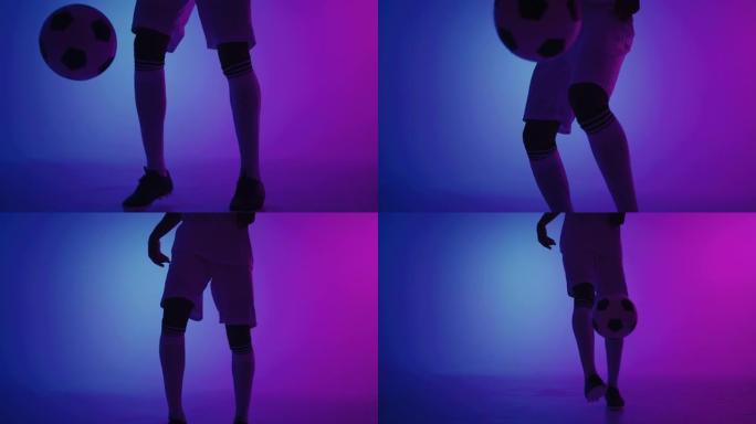 足球运动员在工作室里用蓝色和紫色和双脚特写玩球keepie-uppie