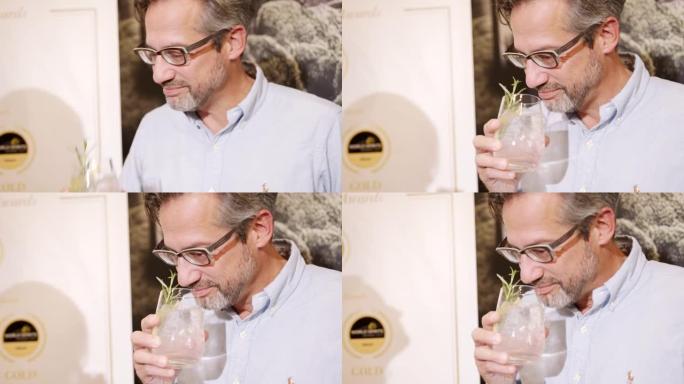 一个男人享受新鲜鸡尾酒的味道的细节镜头