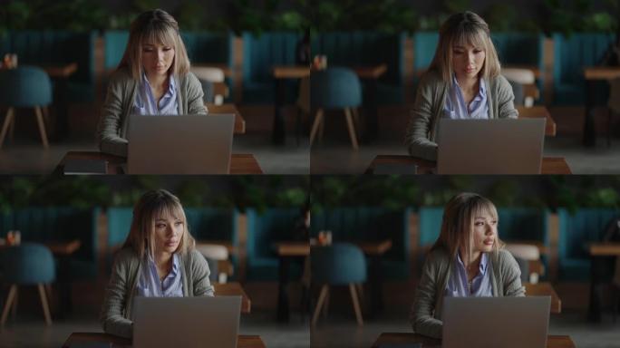一位亚洲妇女坐着沉思，看着笔记本电脑屏幕。头脑风暴，脸上焦虑不安。沉思的亚洲女人