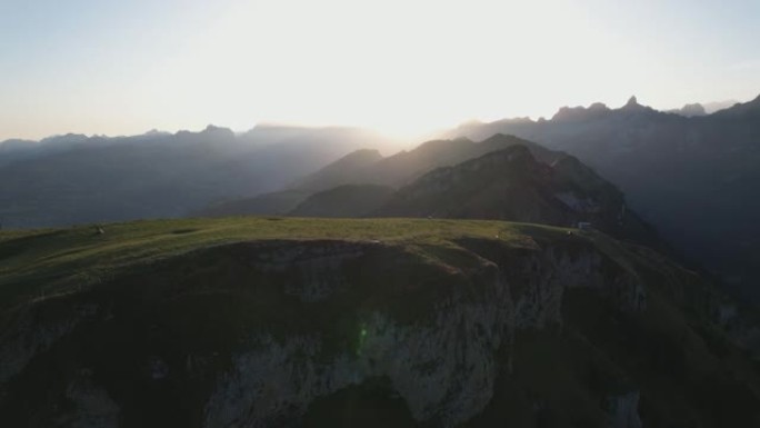 空中无人机拍摄日落时绿草茂盛的山脉