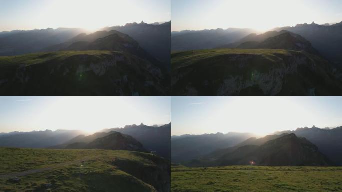 空中无人机拍摄日落时绿草茂盛的山脉