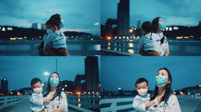年轻的母亲在泰国黄昏时抱着儿子