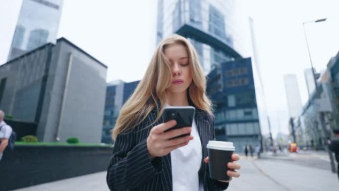 清晨，年轻的金发女子在市中心用纸杯喝咖啡