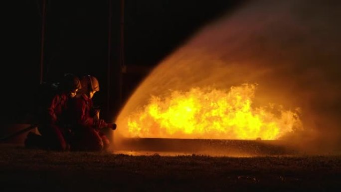 2消防队员在地面用火进行灭火训练