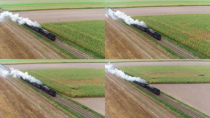 蒸汽火车穿过乡村的田野，鸟瞰图。复古的老式蒸汽机车穿越平原。