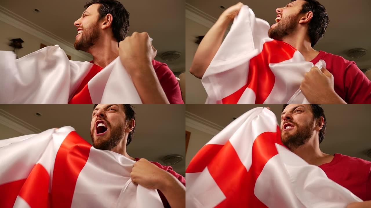 一名英国球迷在家里举着国旗庆祝