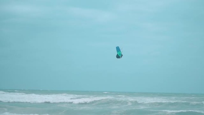 一个冲浪运动员在海滩附近的海洋中跳跃的细节镜头