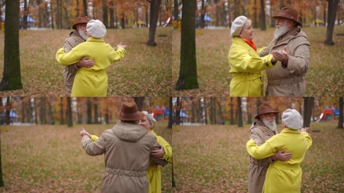 现场摄像机跟随快乐微笑的高级夫妇在户外慢动作中跳舞。在阴天的秋天公园里，热爱无忧无虑的高加索夫妻约会