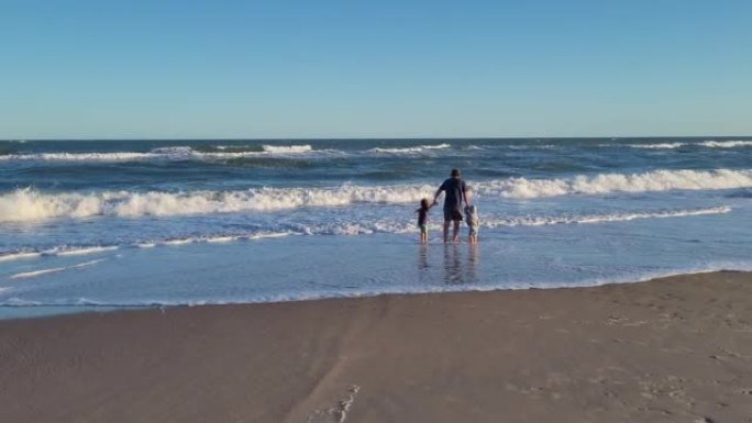 父亲带着他的孩子在海滩上