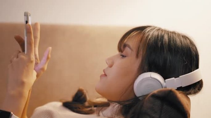 女孩在沙发上听音乐和放松