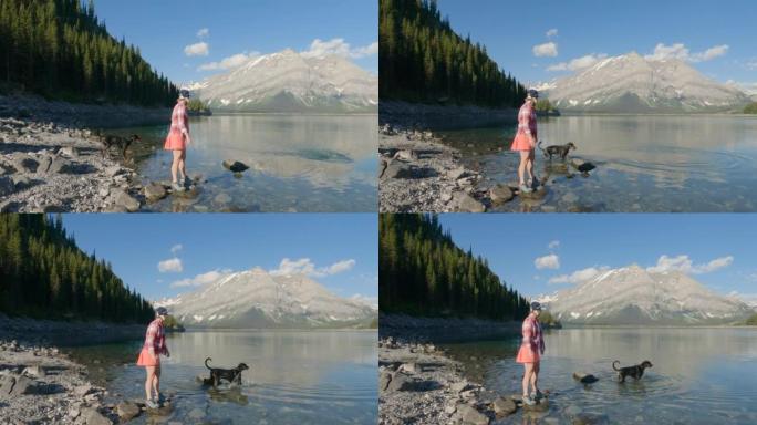女人在山湖畔享受与peg狗的时光
