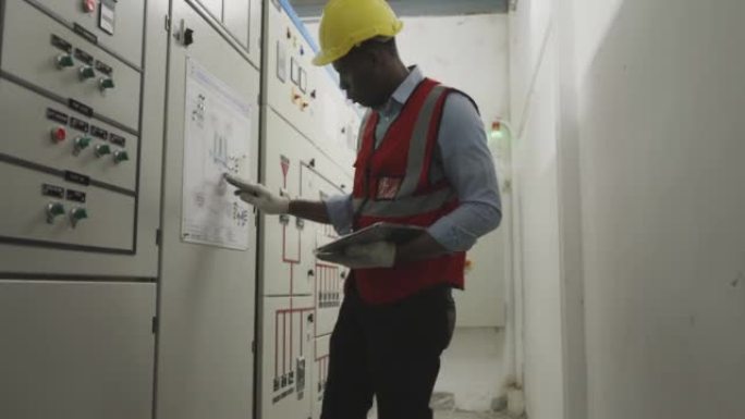 非洲电气工程师在控制室工作。