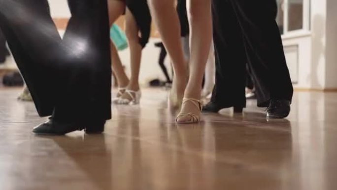 白人男孩和女孩的腿在工作室里跳拉丁交际舞。一群无法辨认的自信的孩子在室内舞蹈学校排练。艺术和生活方式