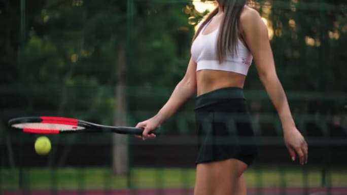 有魅力的女人正在网球场上训练，苗条的身体特写镜头，球员正在击球