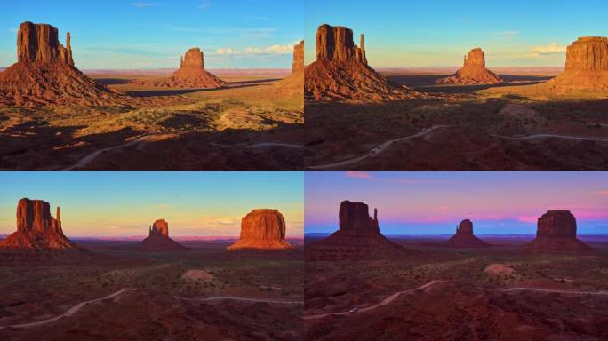 日落时的纪念碑谷。砂岩小山沙漠风光，雄伟的岩层和道路。时间流逝