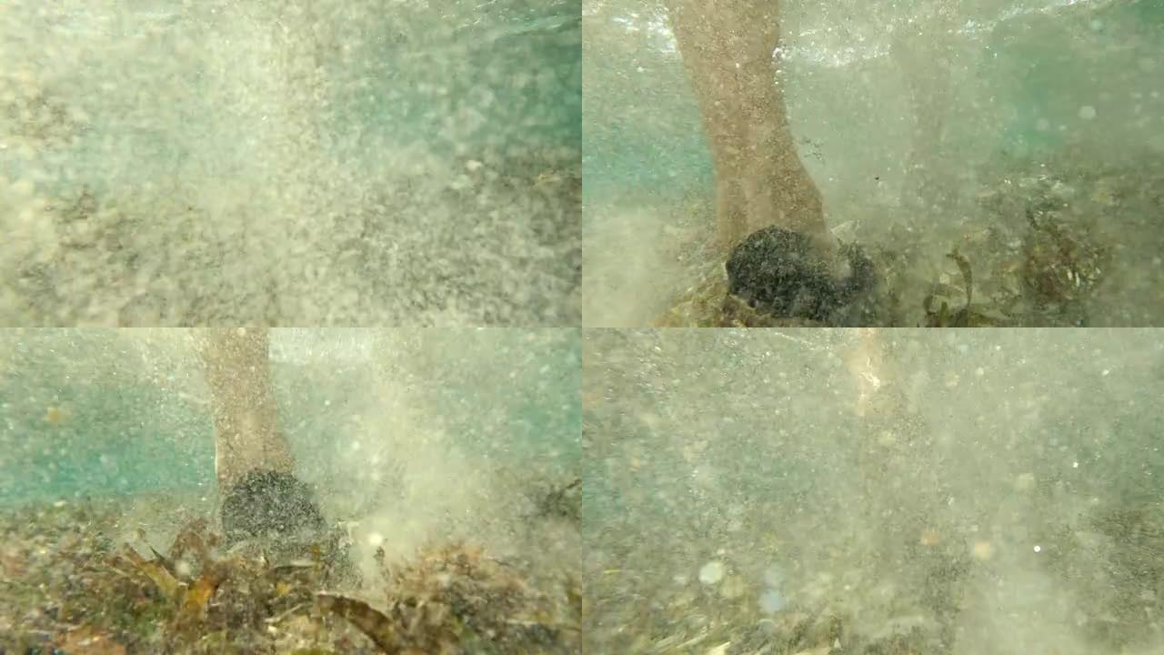 触摸海底。站在水里的人。特写脚