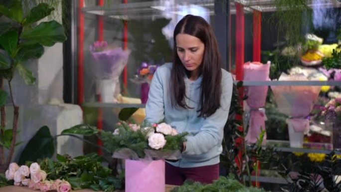 集中的专业花店创造组合提高花束站在车间。在室内花店赏花的白人妇女的肖像。