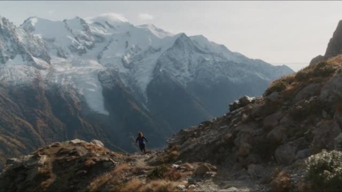 女越野跑者登上岩石小径，背景是勃朗峰