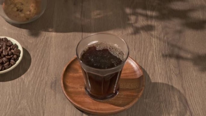 4k video, pouring brewing coffee into glass on woo