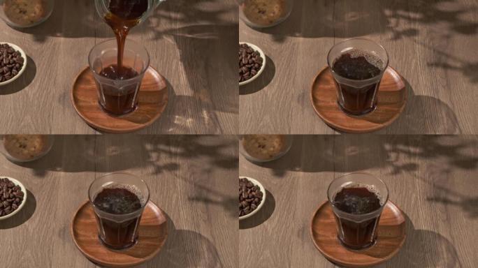 4k video, pouring brewing coffee into glass on woo