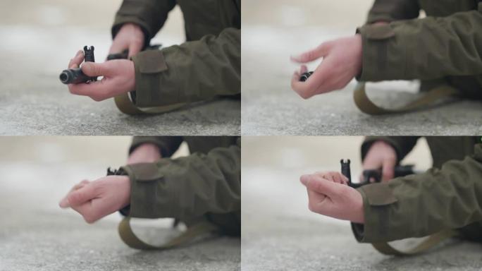 男性士兵的特写镜头，用慢动作将闪光锁在枪上。难以辨认的白种年轻人训练装配武器户外基地或多边形。