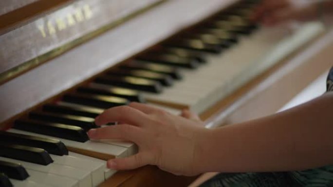 男孩在弹钢琴。家庭教育。双手合十