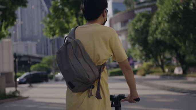 男子在城市乘坐电动踏板车旅行