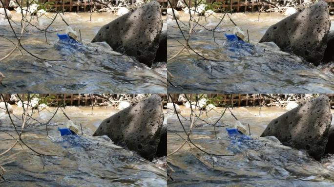 垃圾塞在河水的石头里，水流得很快。山里的一条河里到处都是塑料和聚乙烯。从垃圾垃圾中提出环保概念