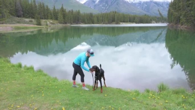 女人带着狗在湖边放松