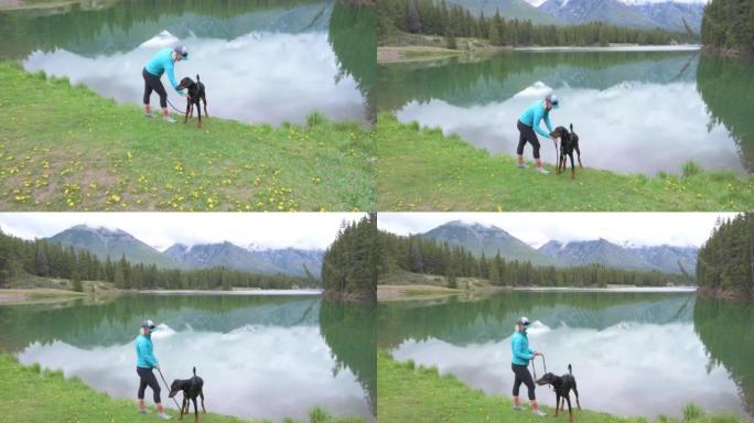 女人带着狗在湖边放松