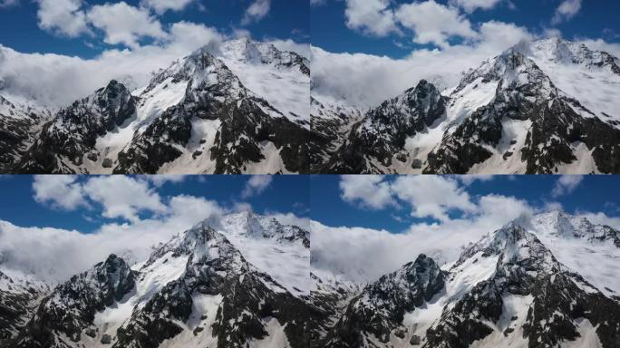 空中飞行穿过山云，飞越美丽的白雪皑皑的山峰和冰川。