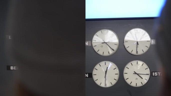 一名妇女在大型世界钟表前的机场拍照的垂直细节照片