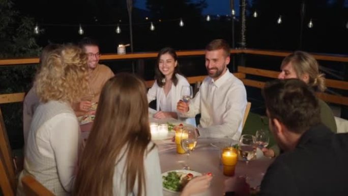 多种族的男女朋友，在餐厅阳台上的晚餐时敬酒