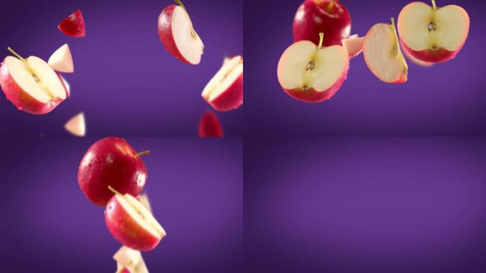 紫色背景下的红苹果和切片的飞行