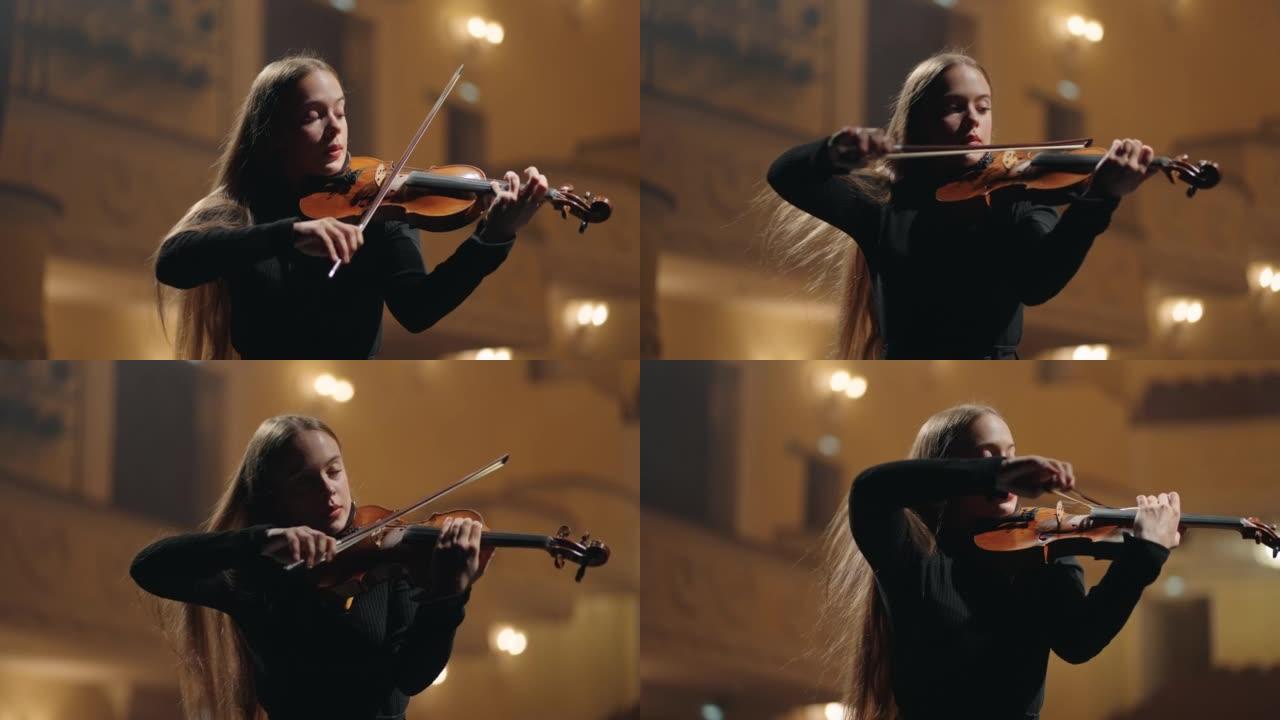 经典音乐音乐会在爱乐音乐厅，年轻的女小提琴手在黑暗中演奏小提琴
