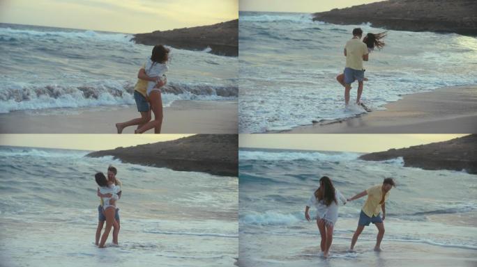 海滩上的浪漫情侣。相爱的情侣牵手拥抱在海浪中