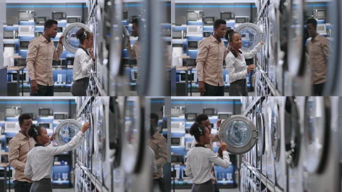 开朗的美国黑人夫妇在五金店选择洗衣机，男人和女人在里面看新型号